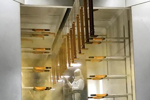 MATCOR Metal Fabrication-Blechbearbeitung-Case Study Metallteile werden mit gelbem Pulver in der MagicCompact EquiFlow Kabine von Gema beschichtet.